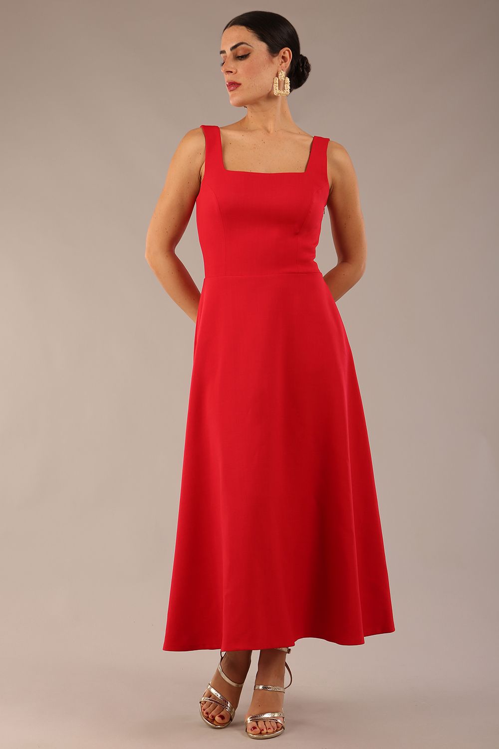 woman wearing a diva catwalk Tamsin Square Neckline Swing Dress sleeveless style with a midaxi  length and side pockets in Scarlet Red colour in Budapest (Scarlet Red)