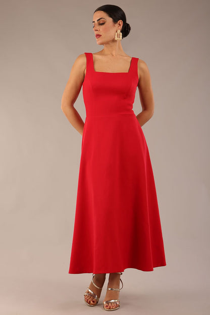 woman wearing a diva catwalk Tamsin Square Neckline Swing Dress sleeveless style with a midaxi  length and side pockets in Scarlet Red colour in Budapest (Scarlet Red)