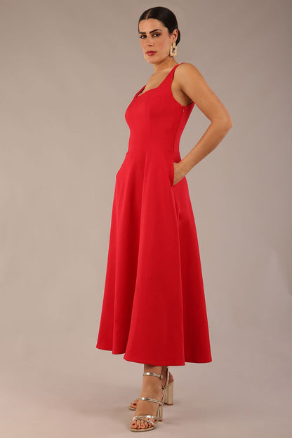woman wearing a diva catwalk Tamsin Square Neckline Swing Dress sleeveless style with a midaxi  length and side pockets in Scarlet Red colour in Budapest (Scarlet Red)