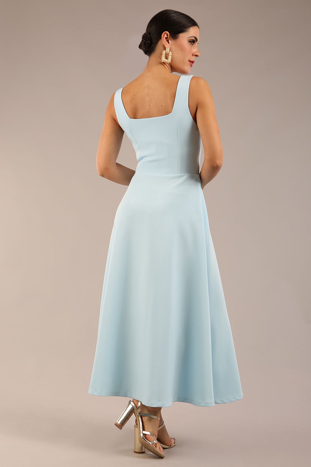brunette model is wearing a diva catwalk Tamsin Square Neckline Swing Dress sleeveless style with a midaxi  length and side pockets in Sky blue colour front