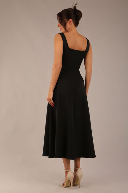 brunette model wearing a diva catwalk Tamsin Square Neckline Swing Dress sleeveless style with a midaxi  length and side pockets in Black colour front (Black)