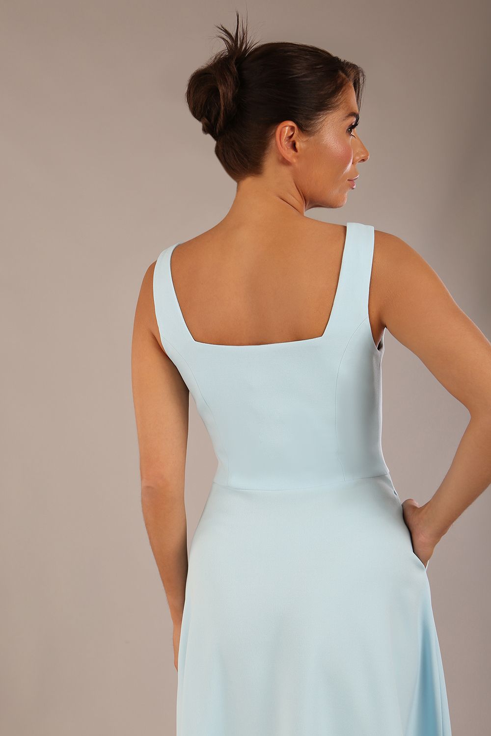 brunette model is wearing a diva catwalk Tamsin Square Neckline Swing Dress sleeveless style with a midaxi  length and side pockets in Sky blue colour front