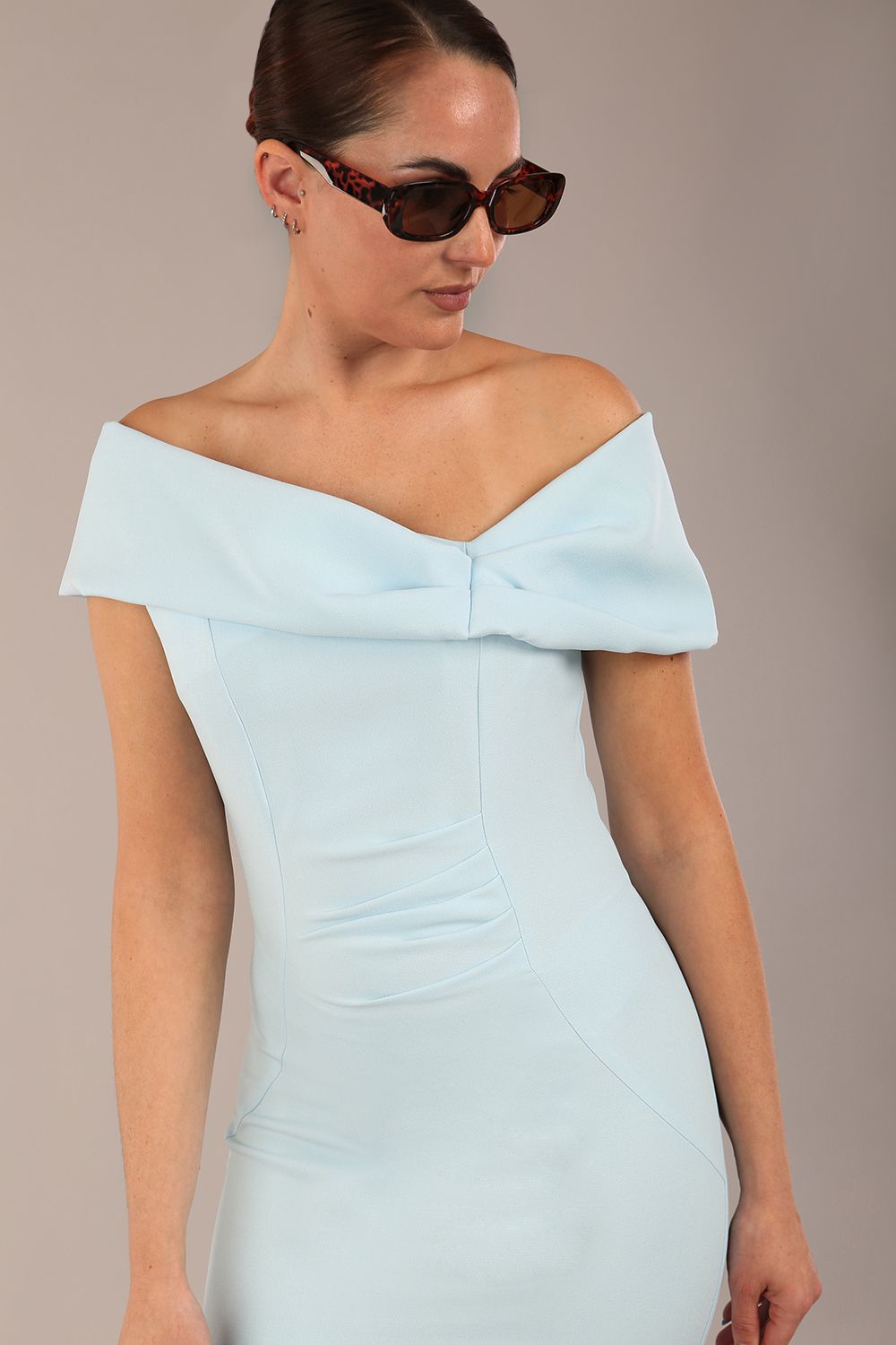 brunette model is wearing a diva catwalk Mariposa Longer Length Dress off the shoulder bardot neckline and midaxi length in sky blue colour front image