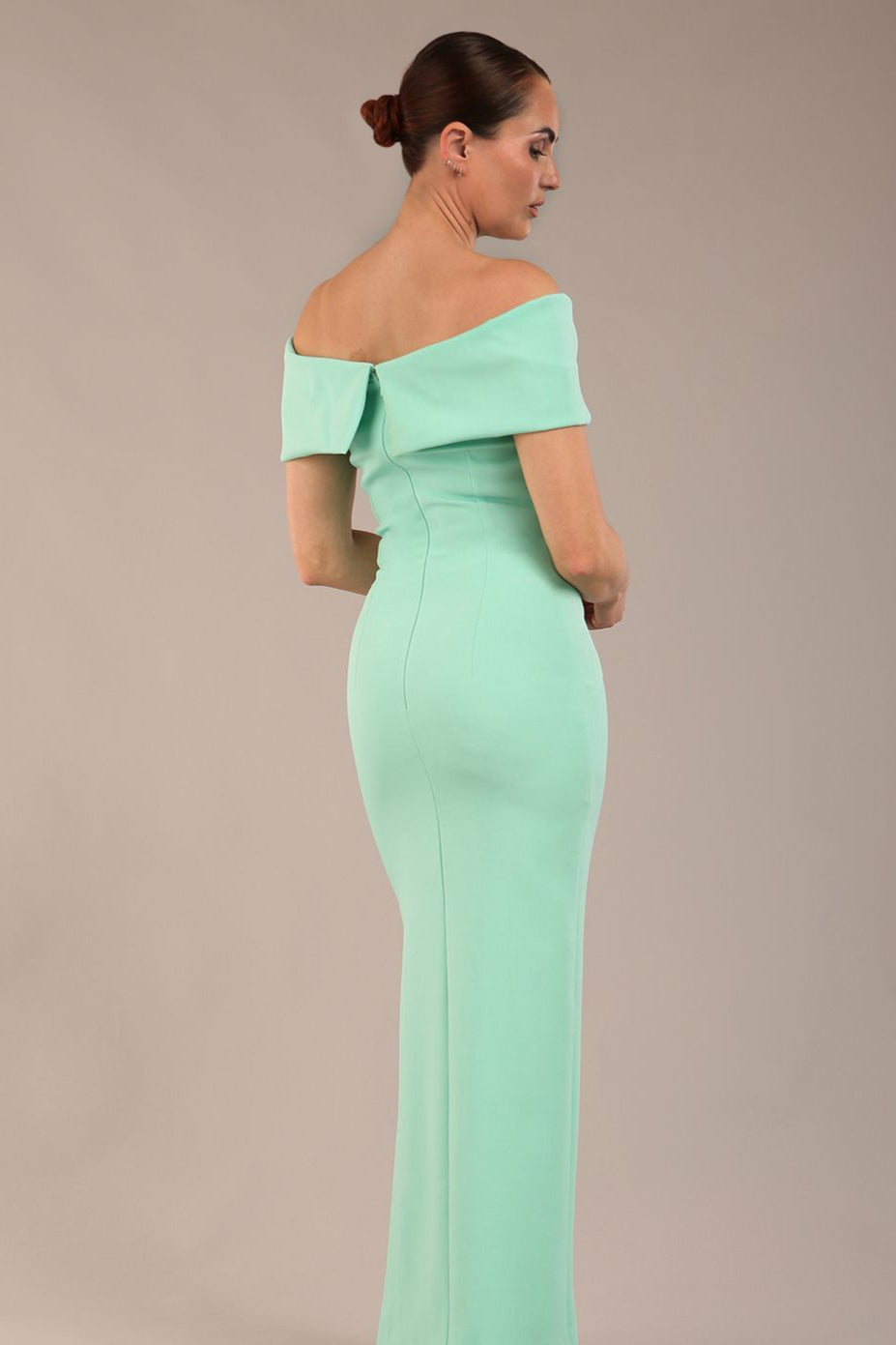 brunette model is wearing a diva catwalk Mariposa Longer Length Dress off the shoulder bardot neckline and midaxi length in mint green colour back image