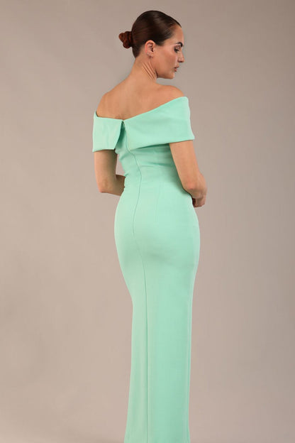 brunette model is wearing a diva catwalk Mariposa Longer Length Dress off the shoulder bardot neckline and midaxi length in mint green colour back image