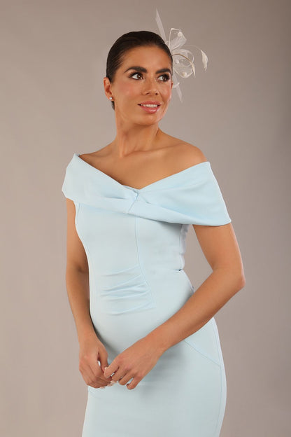 brunette model is wearing a diva catwalk Mariposa Longer Length Dress off the shoulder bardot neckline and midaxi length in sky blue colour front image