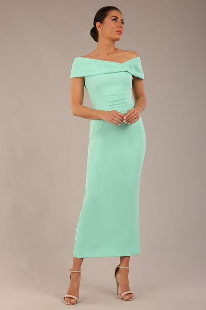 brunette model is wearing a diva catwalk Mariposa Longer Length Dress off the shoulder bardot neckline and midaxi length in mint green colour back image