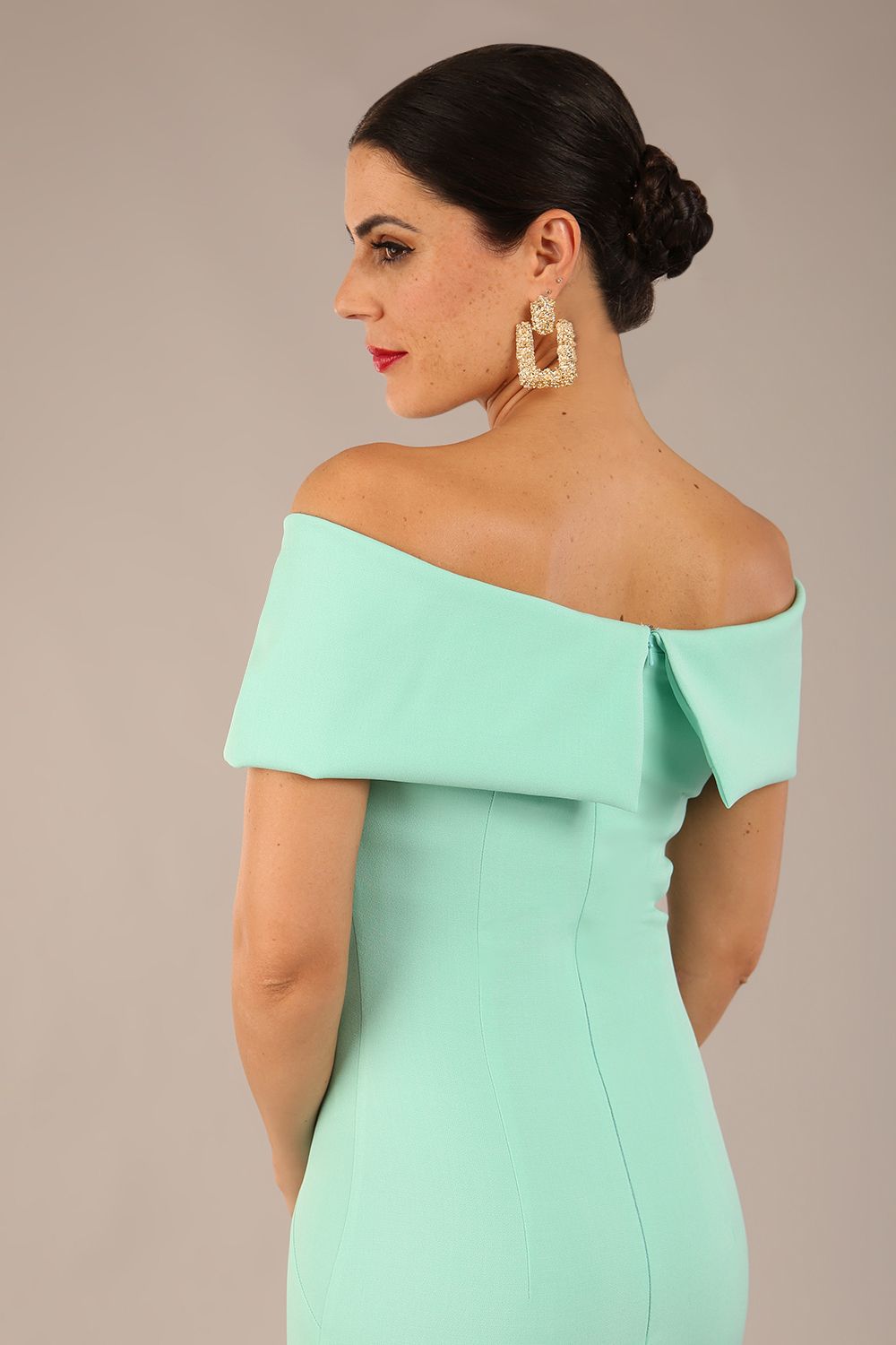 brunette model is wearing a diva catwalk Mariposa Longer Length Dress off the shoulder bardot neckline and midaxi length in mint green colour back image