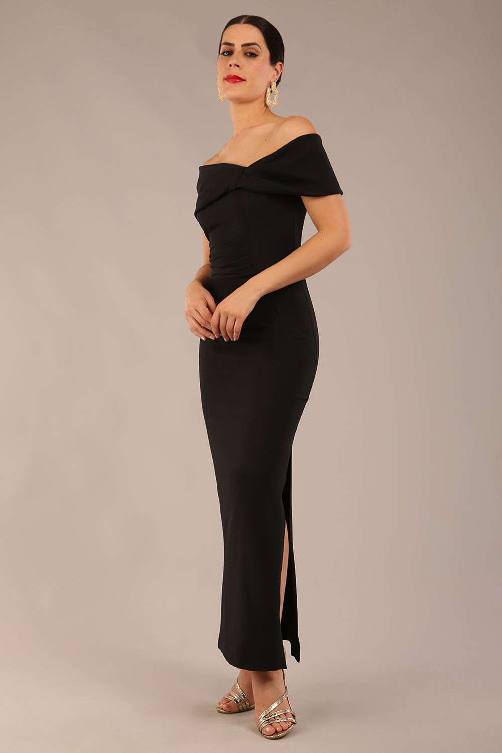 brunette model is wearing a diva catwalk Mariposa Longer Length Dress off the shoulder bardot neckline and midaxi length in black colour back image