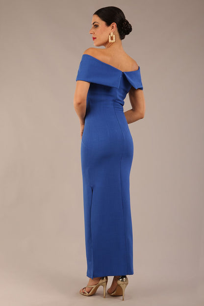 brunette model is wearing a diva catwalk Mariposa Longer Length Dress off the shoulder bardot neckline and midaxi length in cobalt blue colour front image