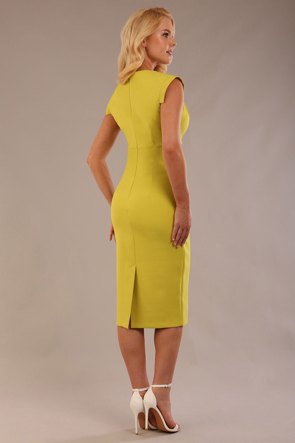 model wearing a diva catwalk Caprice Cap Sleeved Pencil Dress cap sleeve v neckline knee length with pleating details in citrus green colour front