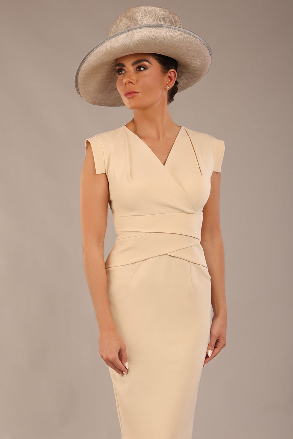 model wearing a diva catwalk Caprice Cap Sleeved Pencil Dress cap sleeve v neckline knee length with pleating details in sandshell beige colour front