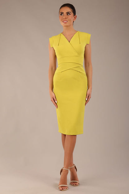 model wearing a diva catwalk Caprice Cap Sleeved Pencil Dress cap sleeve v neckline knee length with pleating details in citrus green colour front