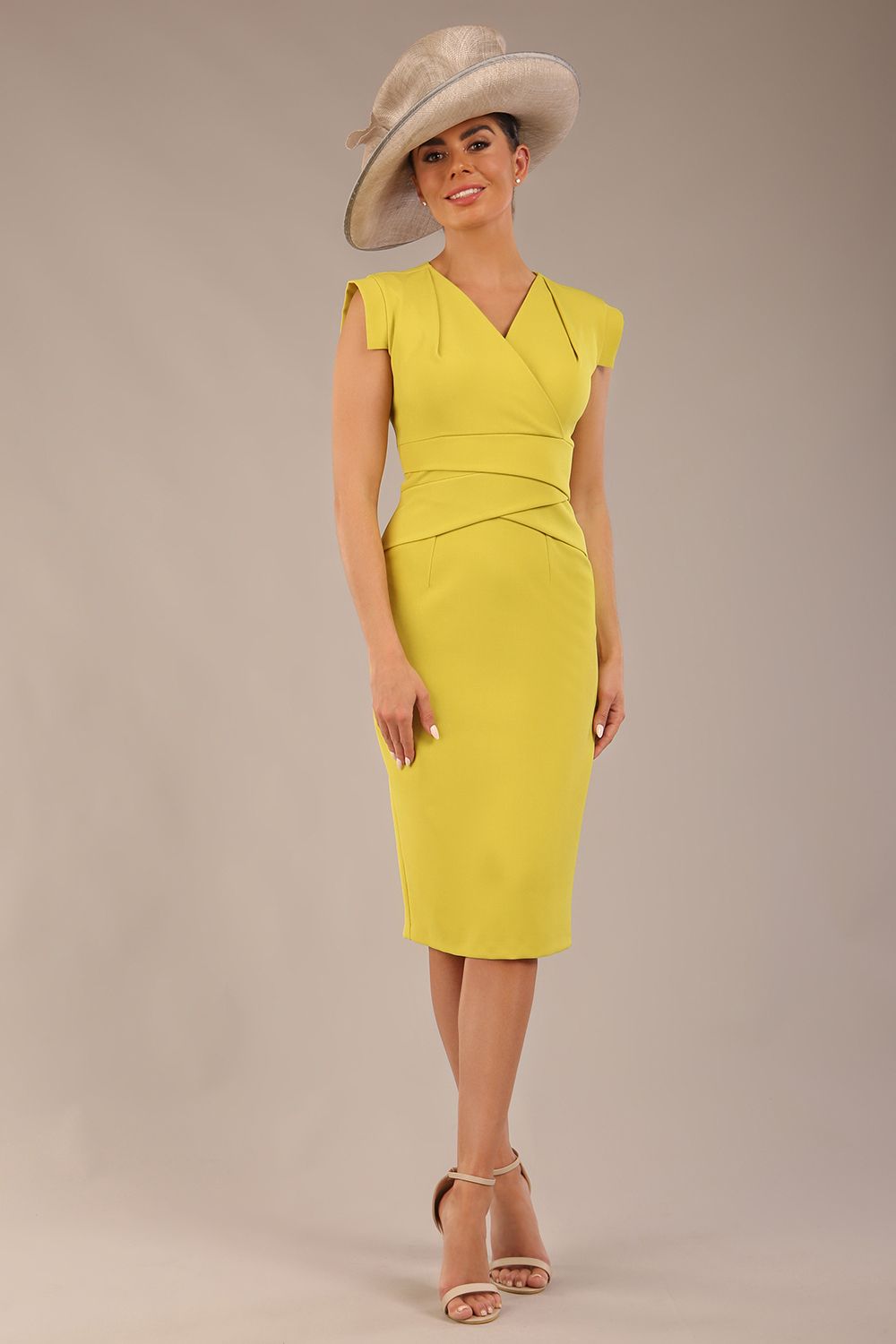 model wearing a diva catwalk Caprice Cap Sleeved Pencil Dress cap sleeve v neckline knee length with pleating details in citrus green colour front