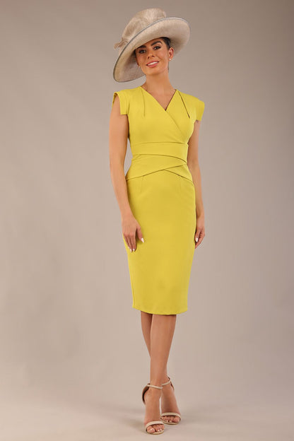 model wearing a diva catwalk Caprice Cap Sleeved Pencil Dress cap sleeve v neckline knee length with pleating details in citrus green colour front