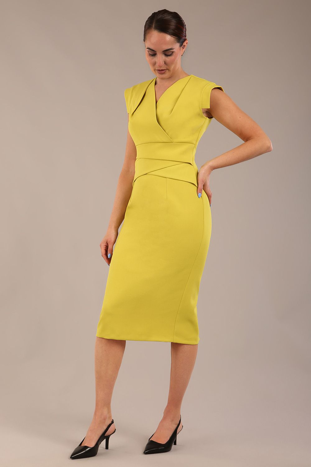 model wearing a diva catwalk Caprice Cap Sleeved Pencil Dress cap sleeve v neckline knee length with pleating details in citrus green colour front