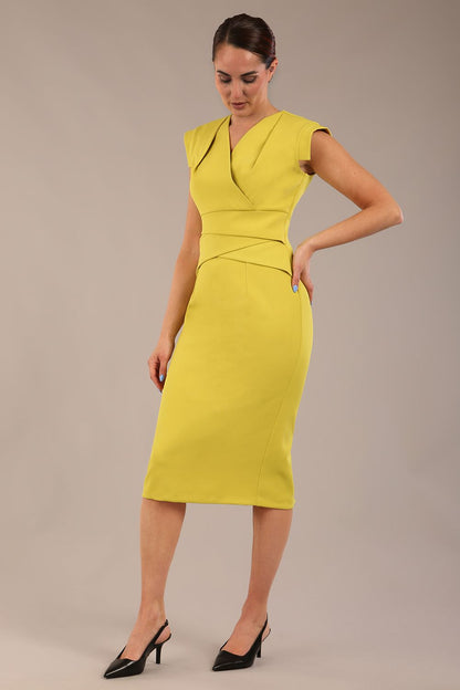 model wearing a diva catwalk Caprice Cap Sleeved Pencil Dress cap sleeve v neckline knee length with pleating details in citrus green colour front
