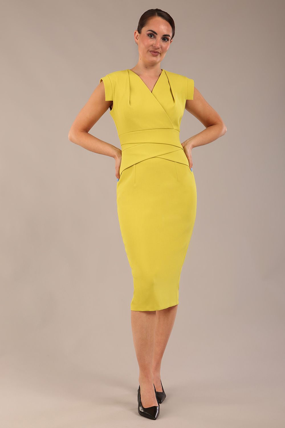 model wearing a diva catwalk Caprice Cap Sleeved Pencil Dress cap sleeve v neckline knee length with pleating details in citrus green colour front