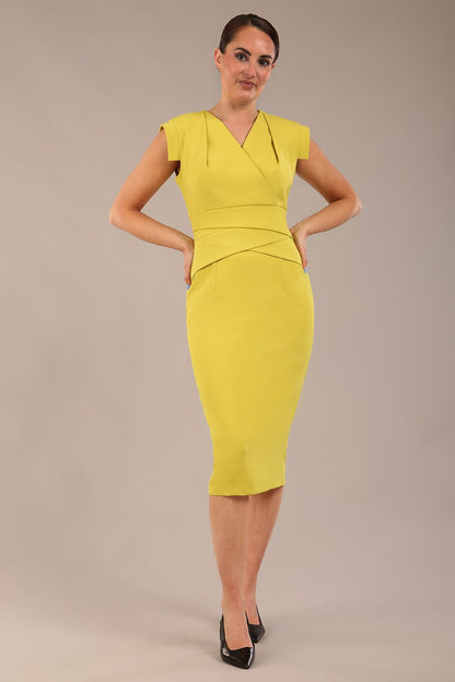 model wearing a diva catwalk Caprice Cap Sleeved Pencil Dress cap sleeve v neckline knee length with pleating details in citrus green colour front