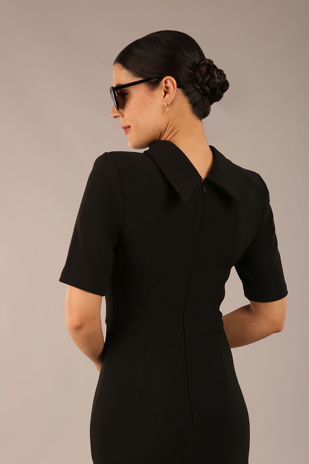model is wearing a diva catwalk Highmoor Short Sleeved Pencil Dress high neckline and shoulders pads in black colour
