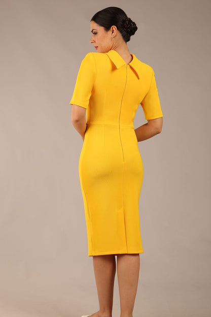 brunette model is wearing a diva catwalk Highmoor Short Sleeved Pencil Dress high neckline and shoulders pad in sunshine yellow colour back image close up