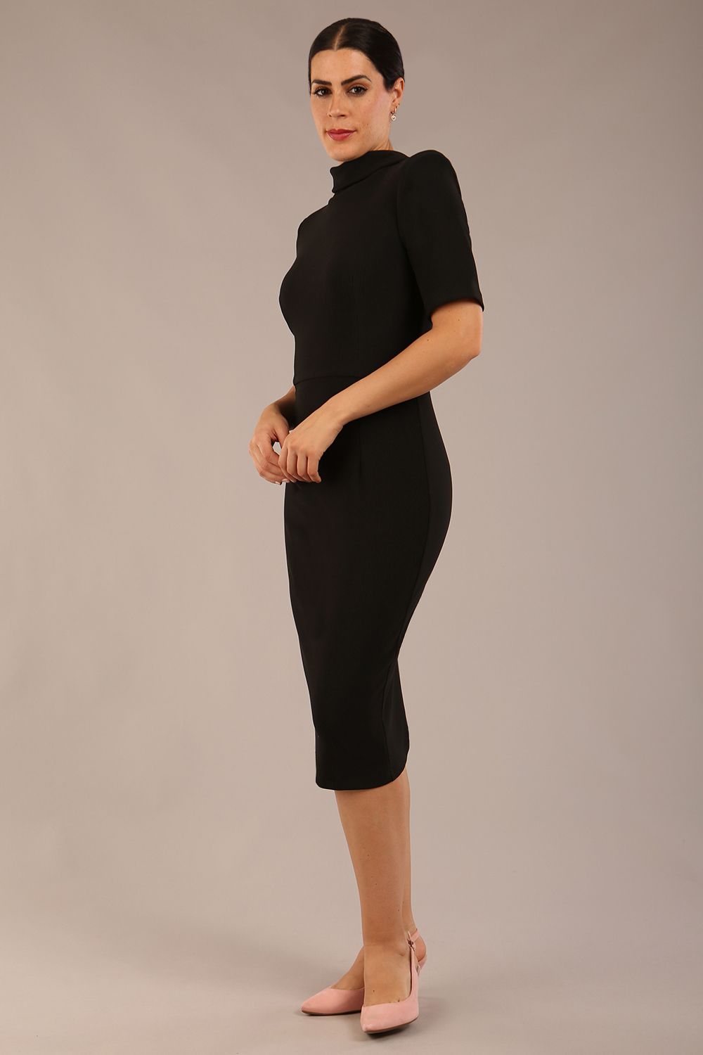 model is wearing a diva catwalk Highmoor Short Sleeved Pencil Dress high neckline and shoulders pads in black colour