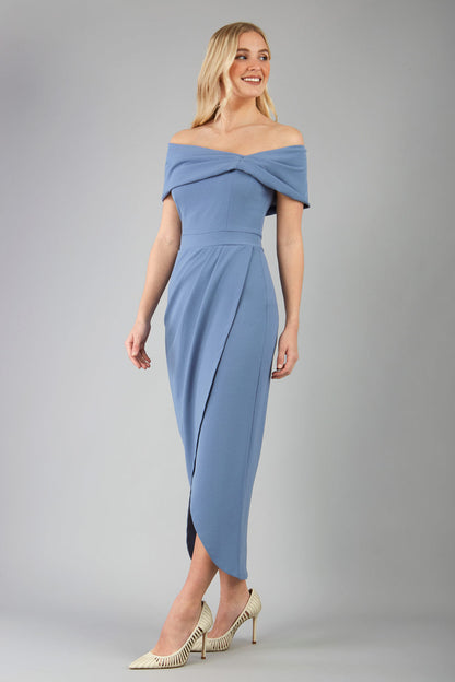 model wearing diva catwalk vegas calf length stone blue midaxi dress with wide bardot neckline and open shoulders with a large opening at the front of the skirt with pleating coming down long skirt front (Stone Blue)