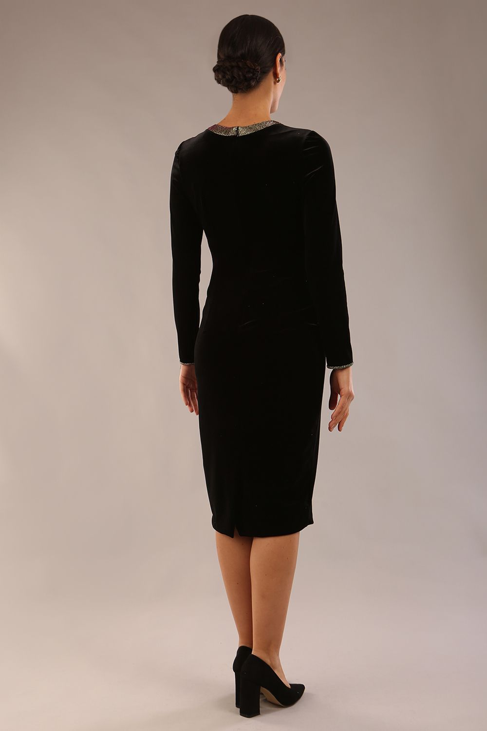 model wearing a diva catwalk Caspian Glitter Contrast Pencil Dress in velvet fabric with glitter contrast on neckline, bodice and cuff and long sleeves knee length pencil dress with faux pockets in black and gold glitter