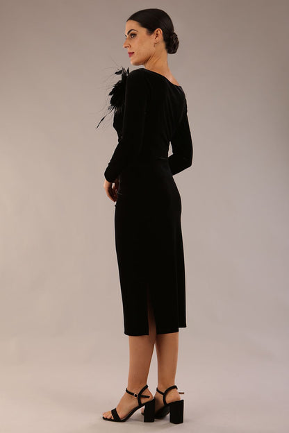 model is wearing a diva catwalk Renoir Long Sleeve Velvet Dress long sleeves midi length with side vent and asymmetric neckline and pleating details in black velvet