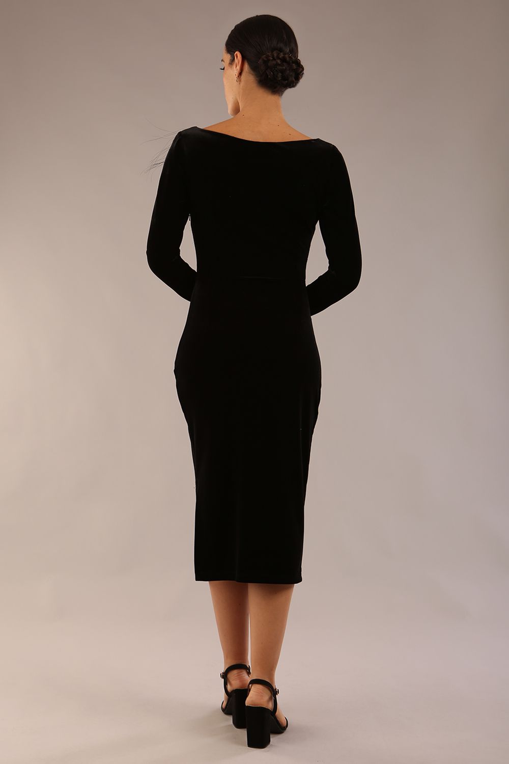 model is wearing a diva catwalk Renoir Long Sleeve Velvet Dress long sleeves midi length with side vent and asymmetric neckline and pleating details in black velvet