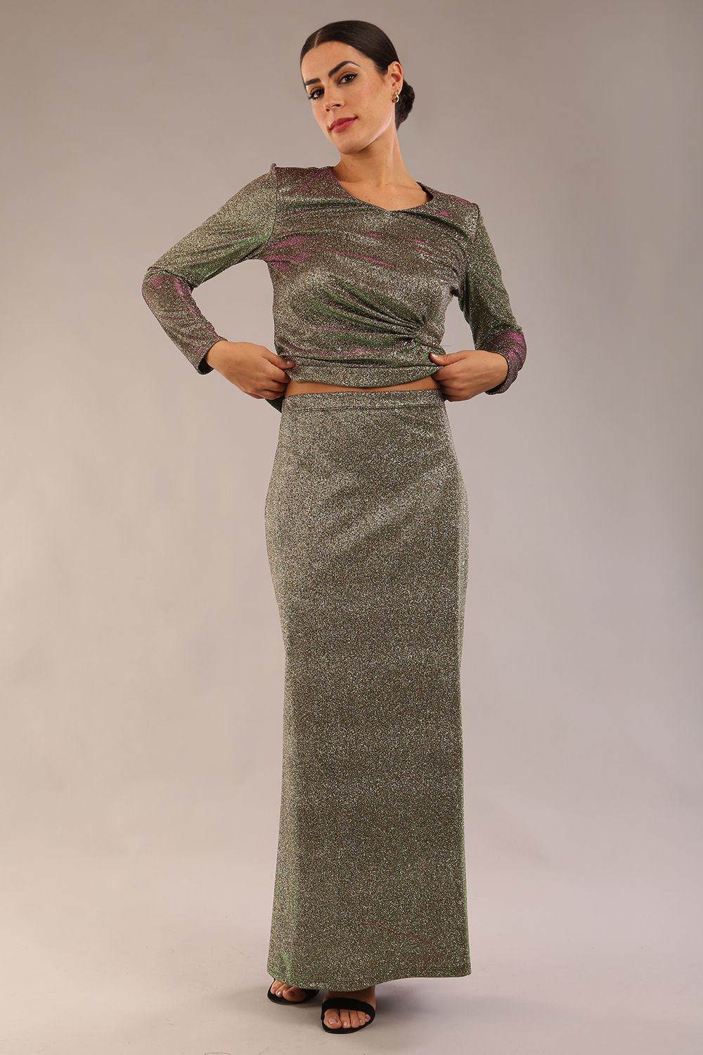 model wearing a diva catwalk Zeta Glitter Two-Piece Set with long sleeves v neckline and gathered detail on the top and side slit detail on the full length skirt in glitter stretch fabric in sherwood glitter colour - 2 pieces