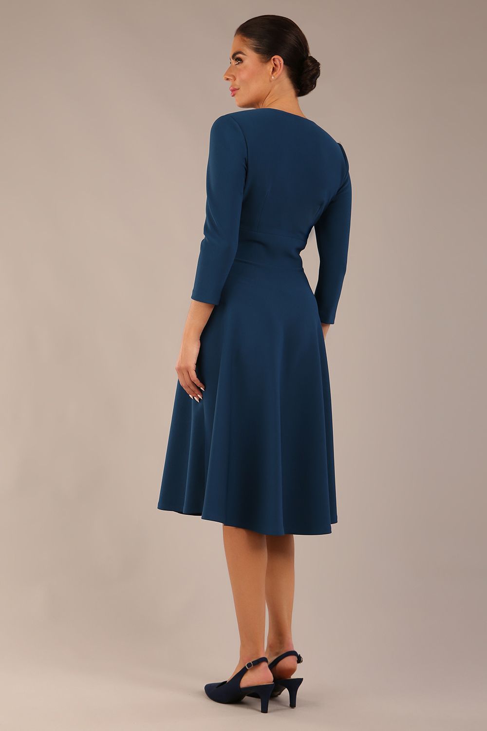 brunette model is wearing a diva catwalk Haddington sleeved A-line Dress knee length round neckline with crossover v-slit detail in teal colour front image