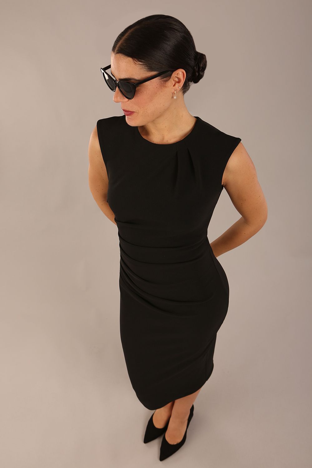 model is wearing a diva catwalk sleeveless dress with round neckline with pleating details and knee length in black colour front