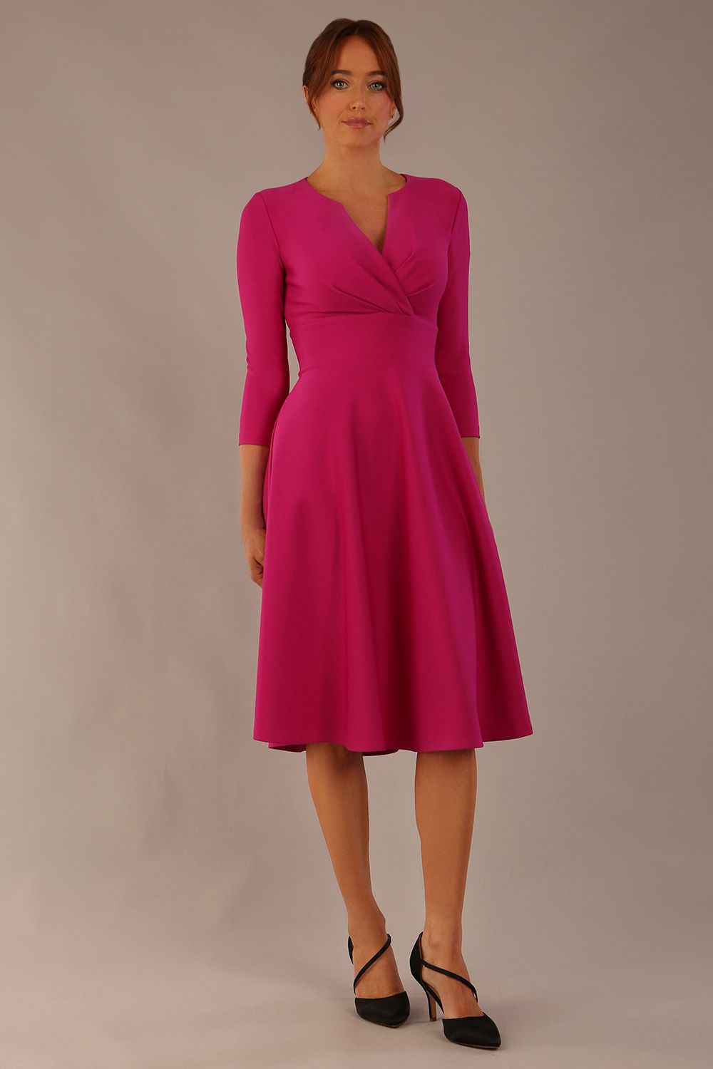 brunette model is wearing a diva catwalk Haddington sleeved A-line Dress knee length round neckline with crossover v-slit detail in magenta colour front image close up
