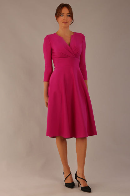 brunette model is wearing a diva catwalk Haddington sleeved A-line Dress knee length round neckline with crossover v-slit detail in magenta colour front image close up