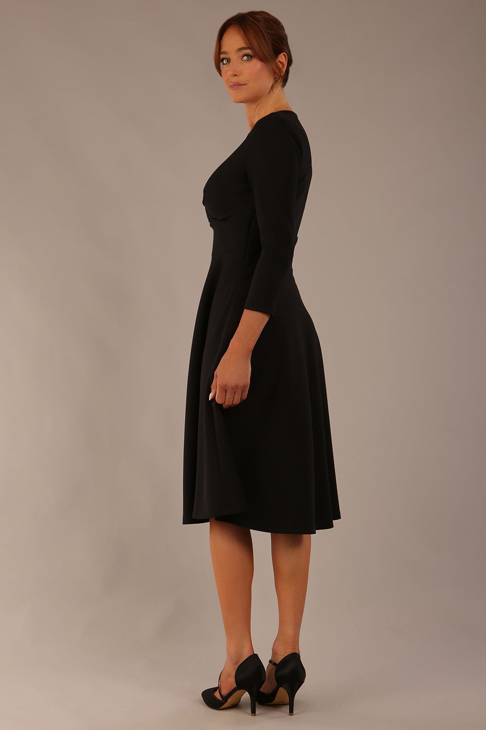 brunette model is wearing a diva catwalk Haddington sleeved A-line Dress knee length round neckline with crossover v-slit detail in black colour front image 