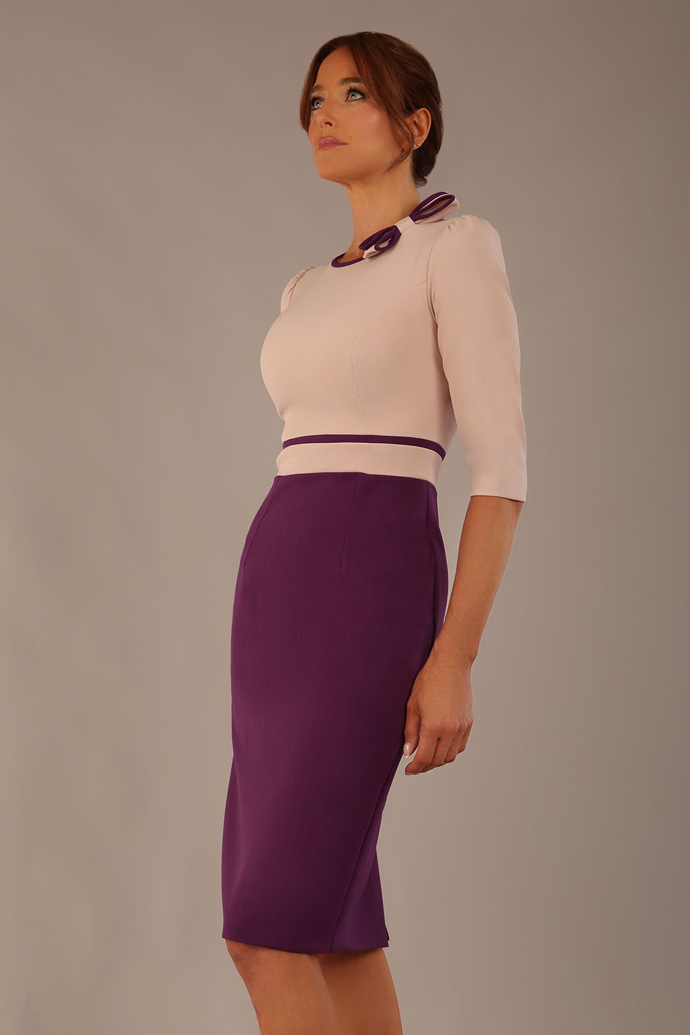 brunette model is wearing a diva catwalk Cherie Sleeved Contrast Bow Neck Pencil Dress round neckline  in Purple and Pink Haze front image (Purple-Pink Haze)