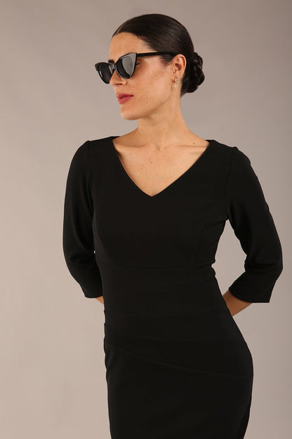 brunette model is wearing a  diva catwalk Tara V-neckline Sleeved Pencil Dress knee length in black colour front image with sunglasses