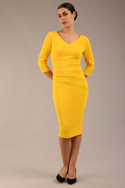 brunette model is wearing a  diva catwalk Tara V-neckline Sleeved Pencil Dress knee length in sunshine yellow colour front image with sunglasses