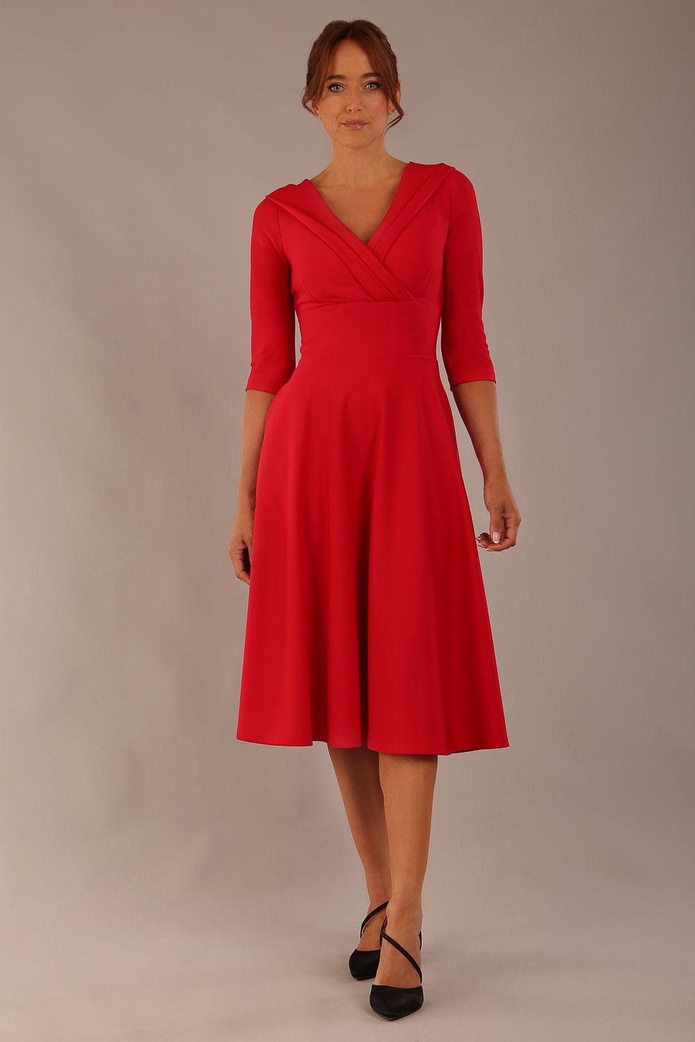 brunette model is wearing a diva catwalk Fabienne sleeved A-line Dress with pockets v neckline knee length wide waistband fold over v neckline in electric red colour front image (Electric Red)