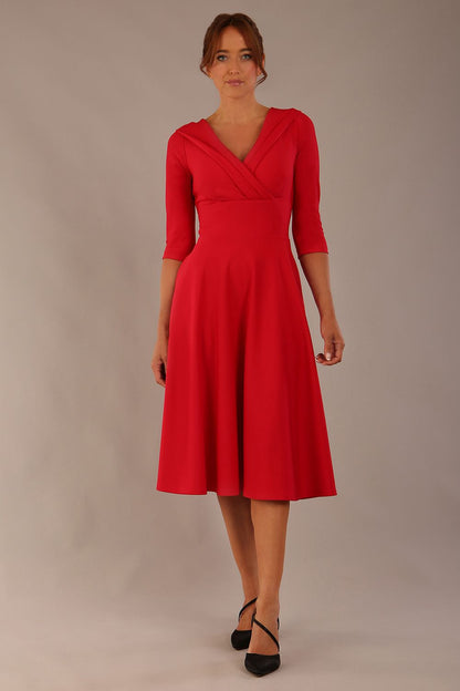 brunette model is wearing a diva catwalk Fabienne sleeved A-line Dress with pockets v neckline knee length wide waistband fold over v neckline in electric red colour front image (Electric Red)