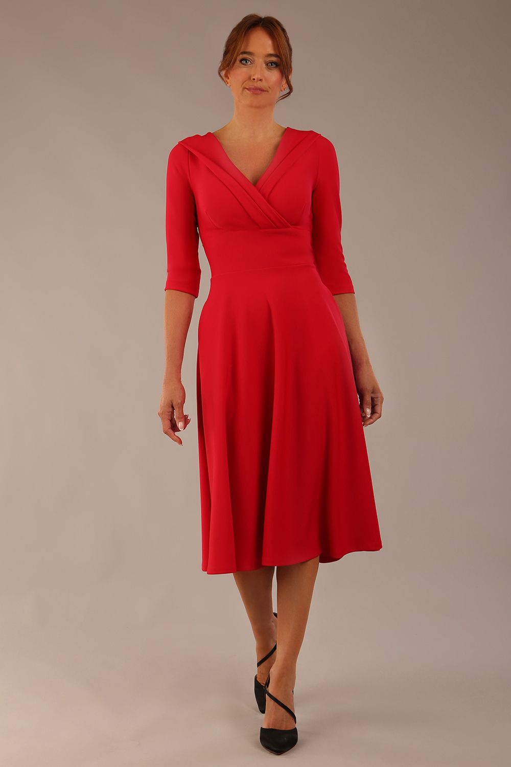 brunette model is wearing a diva catwalk Fabienne sleeved A-line Dress with pockets v neckline knee length wide waistband fold over v neckline in electric red colour front image (Electric Red)