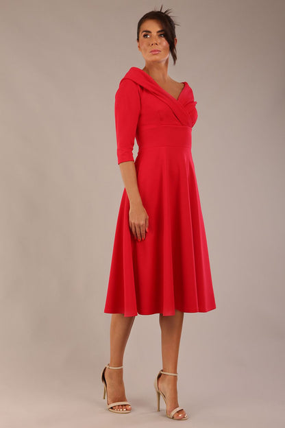 brunette model is wearing a diva catwalk Fabienne sleeved A-line Dress with pockets v neckline knee length wide waistband fold over v neckline in electric red colour front image (Electric Red)