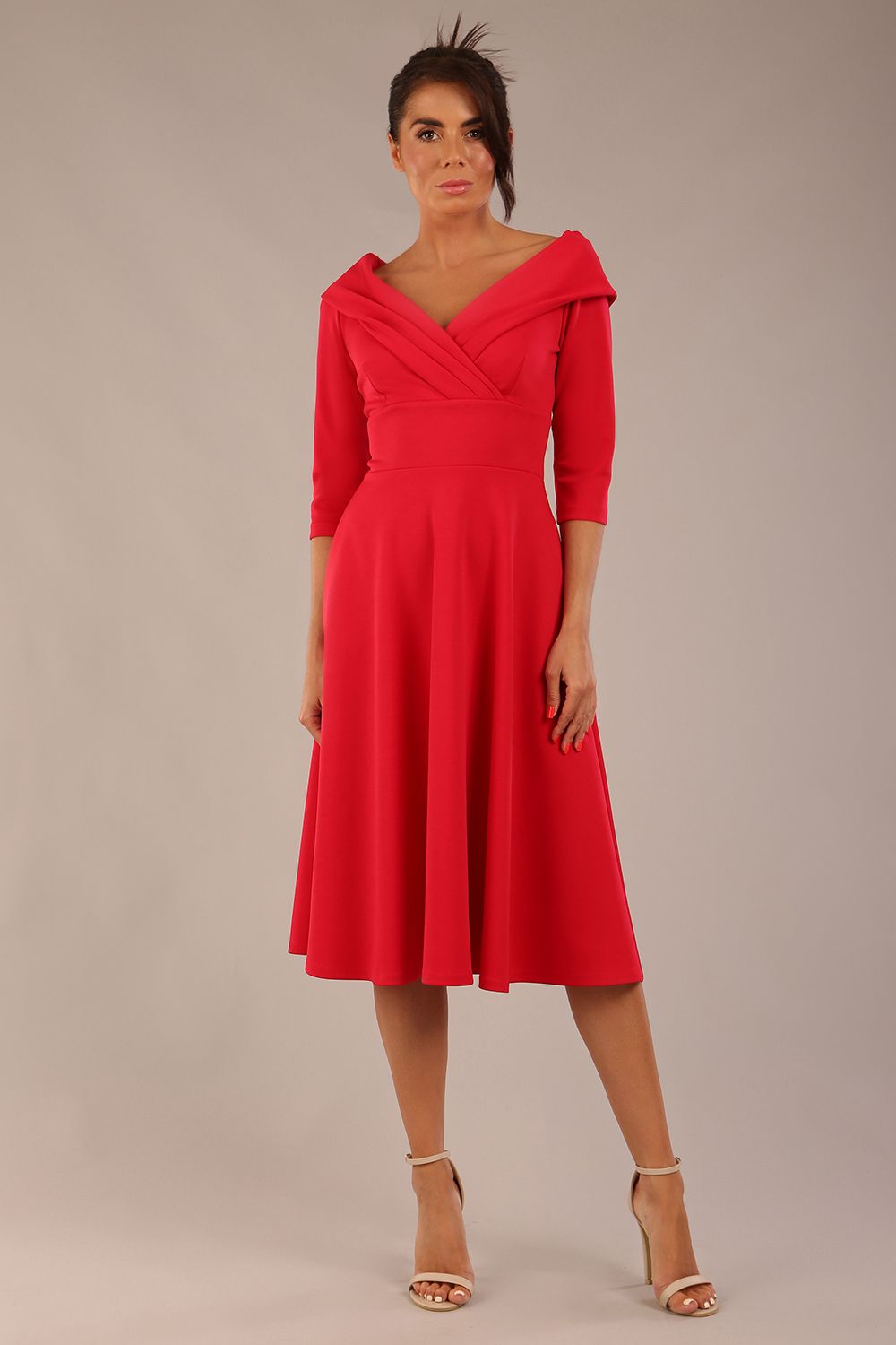 brunette model is wearing a diva catwalk Fabienne sleeved A-line Dress with pockets v neckline knee length wide waistband fold over v neckline in electric red colour front image (Electric Red)
