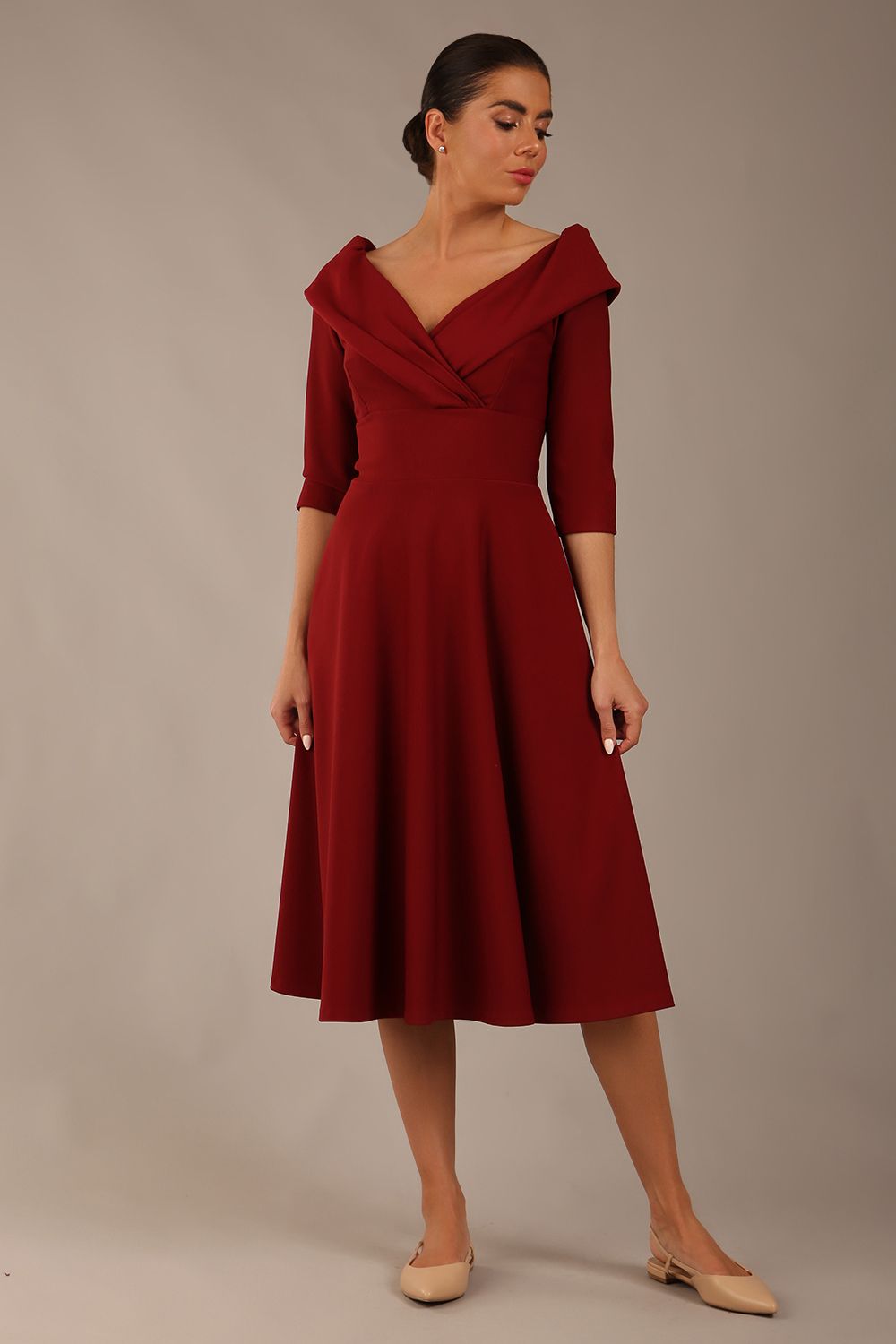 brunette model is wearing a diva catwalk Fabienne sleeved A-line Dress with pockets v neckline knee length wide waistband fold over v neckline in burgundy colour front image (Rio Red)