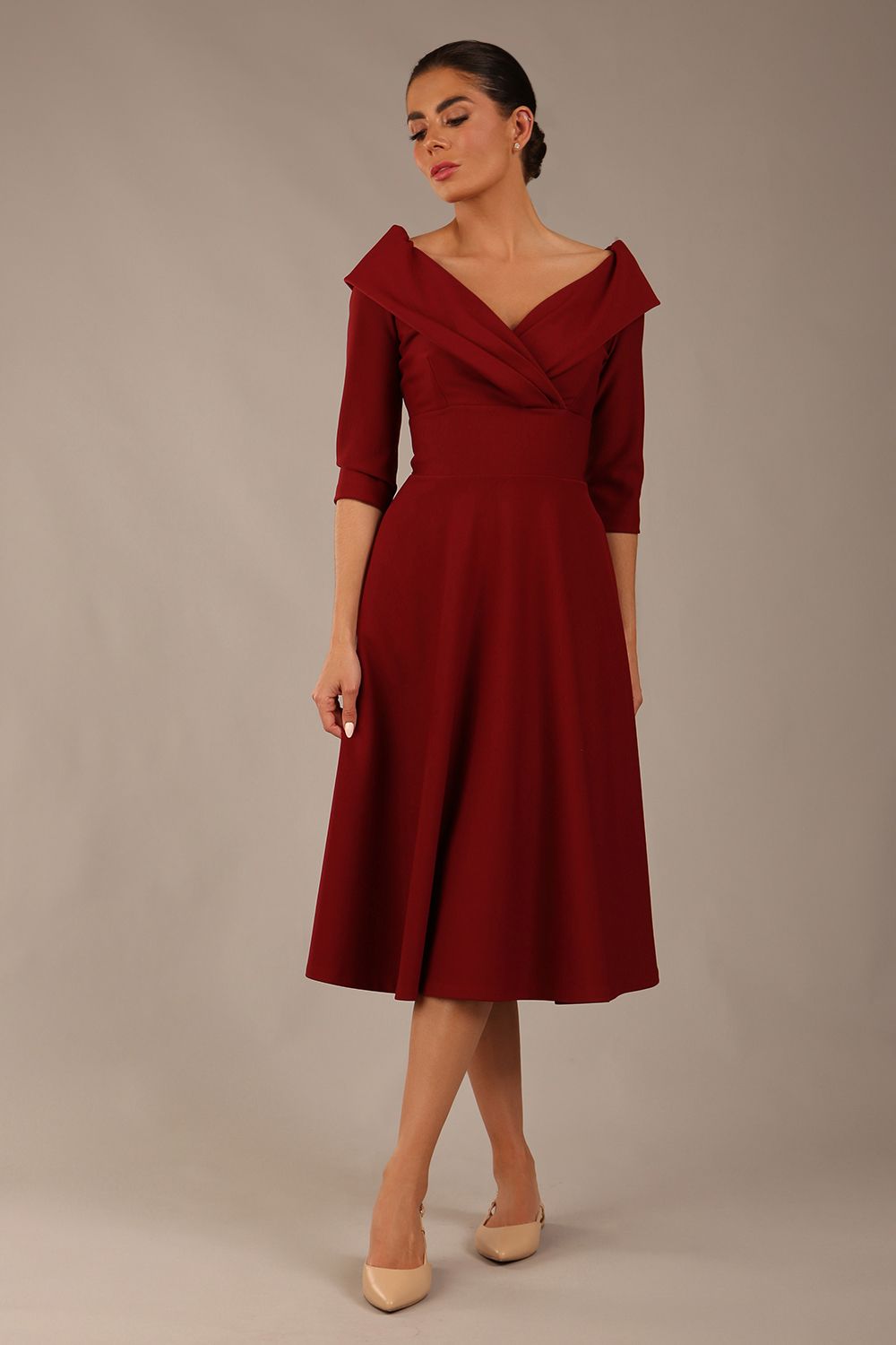 brunette model is wearing a diva catwalk Fabienne sleeved A-line Dress with pockets v neckline knee length wide waistband fold over v neckline in burgundy colour front image (Rio Red)