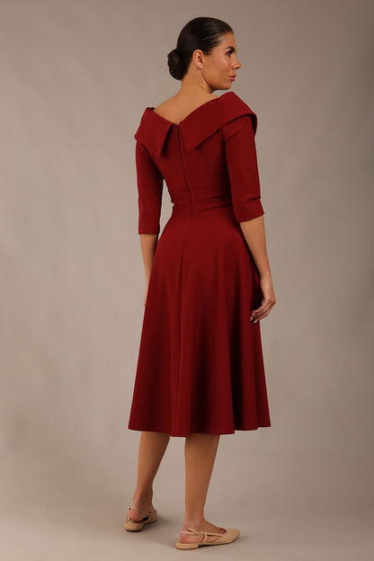 brunette model is wearing a diva catwalk Fabienne sleeved A-line Dress with pockets v neckline knee length wide waistband fold over v neckline in burgundy colour front image (Rio Red)