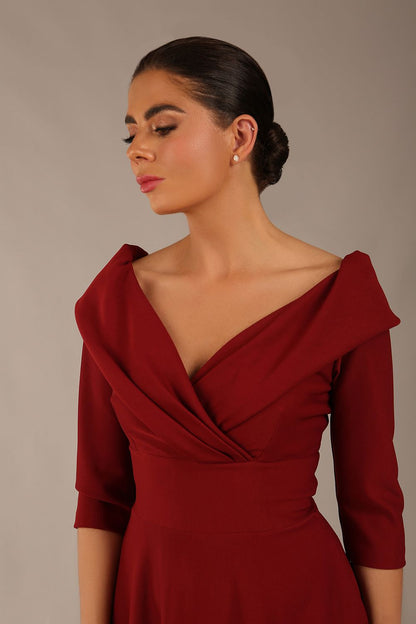 brunette model is wearing a diva catwalk Fabienne sleeved A-line Dress with pockets v neckline knee length wide waistband fold over v neckline in burgundy colour front image (Rio Red)