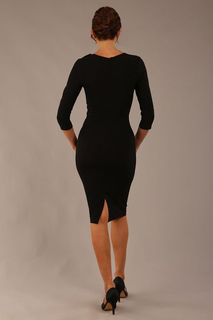 brunette model is wearing a diva catwalk Mirabelle ¾ Sleeves & Floral Shoulder Detail Pencil Dress with diagonal pleating across the front knee length in black colour front image