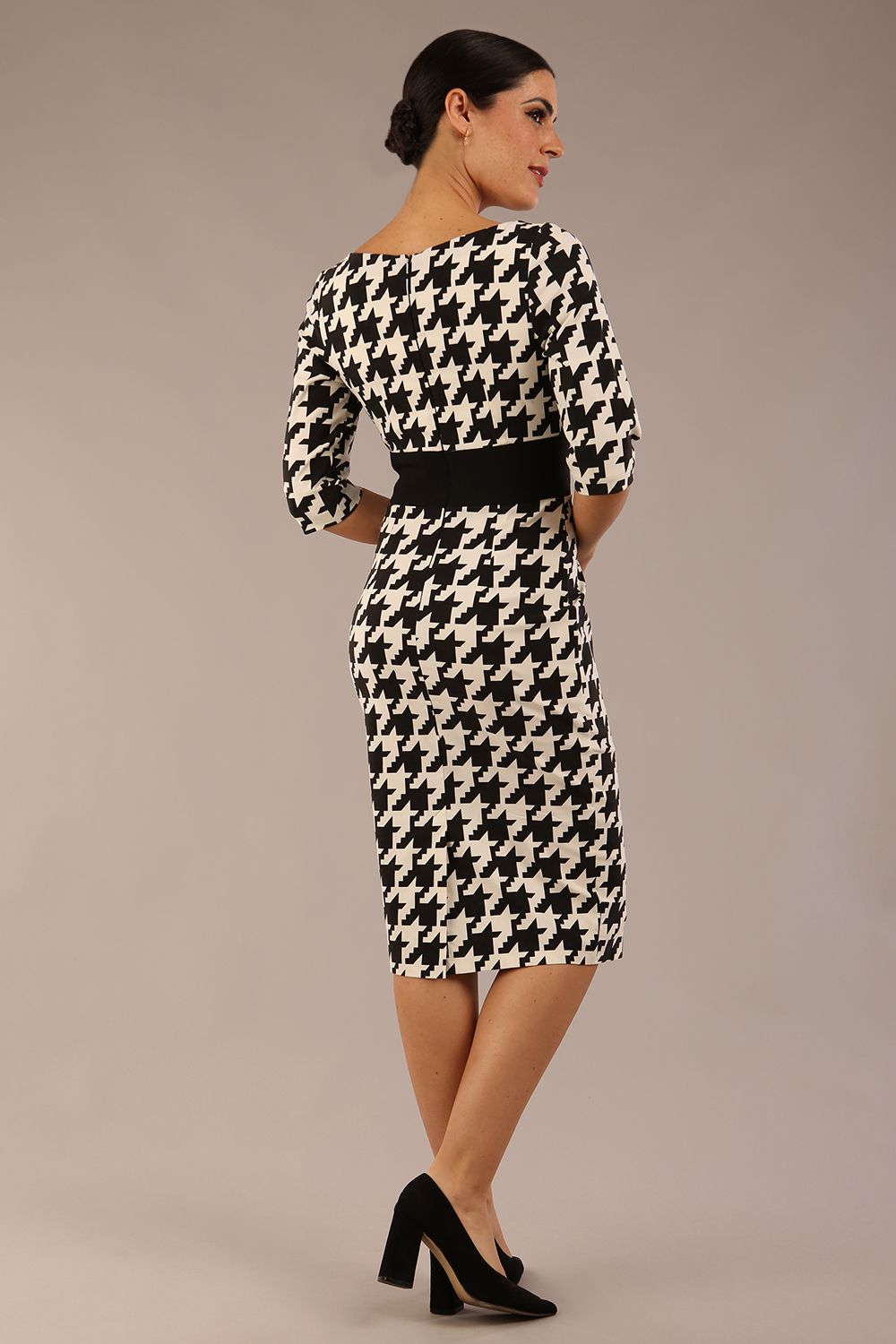 brunette model is wearing a diva catwalk OP-ART V-Neck Sleeved Monochrome Pencil Dress with black waistband and flower detail in a Super stretch dogtooth fabric black and white print front image